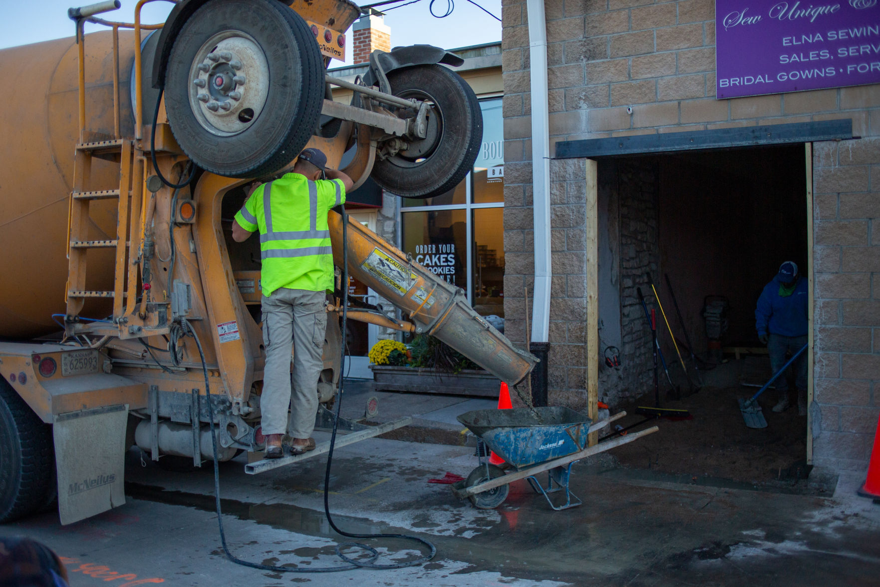 Behind Poyntz Avenue across from the community house concrete is poured into wheelbarrow and poured inside of Weisner Bridal Boutique on Thursday evening.
